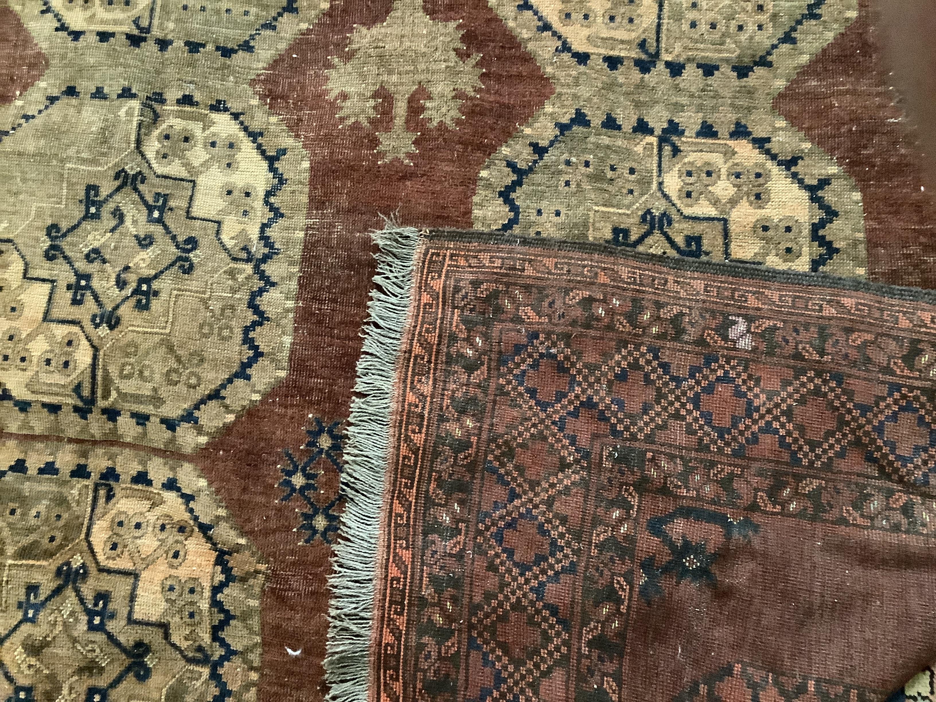 An Afghan brick red ground carpet, 379 x 240cm